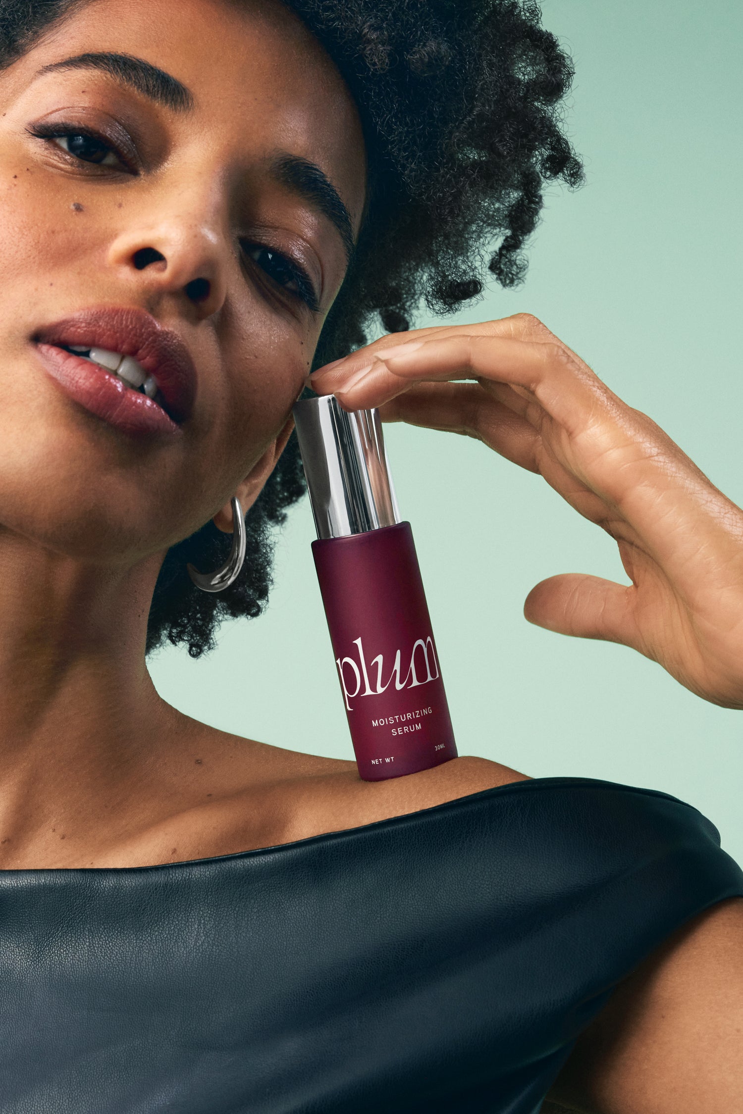 Model holding Plum Moisturizing Serum